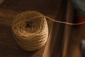 Detailed view of brown twine roll on a wooden table, perfect for crafting and DIY projects.